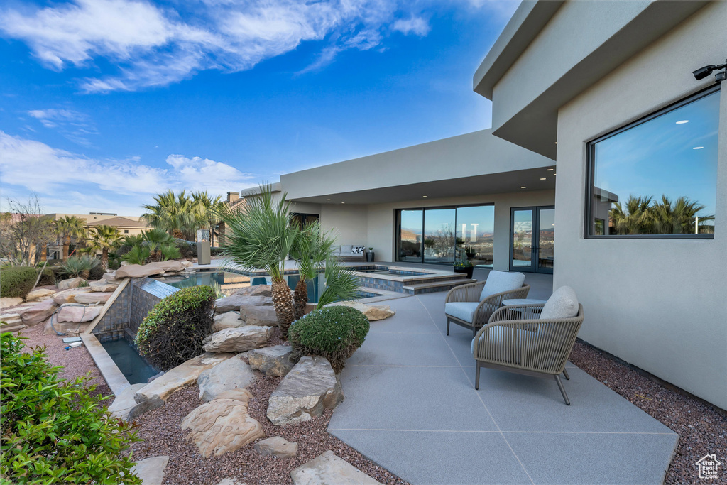 View of patio with a pool with connected hot tub