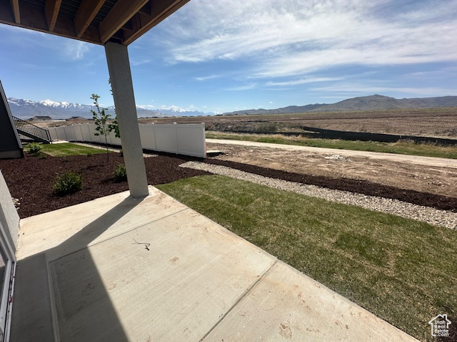 View of yard featuring a patio, a fenced backyard, and a mountain view