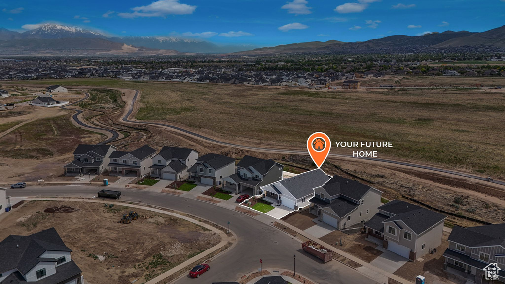 Aerial view of property's location featuring a mountain backdrop and nearby suburban area