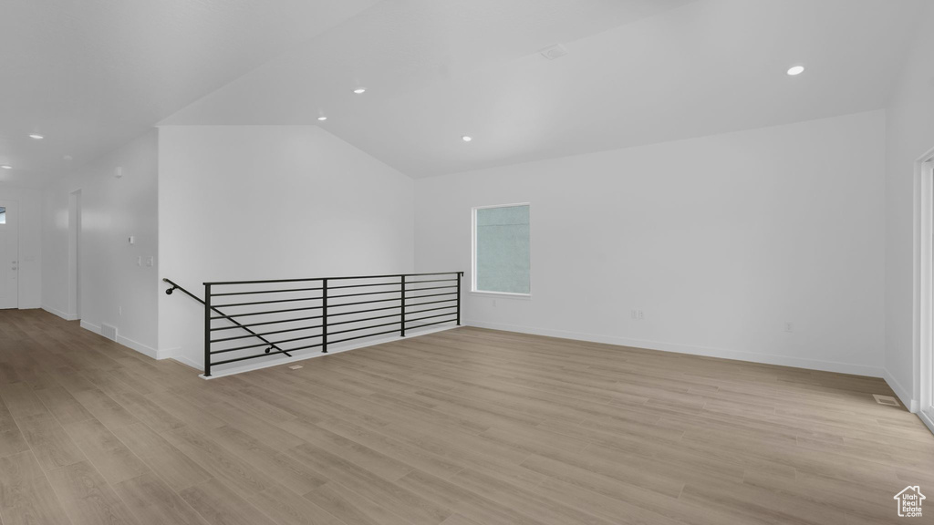 Additional living space featuring light wood-style flooring, baseboards, lofted ceiling, and recessed lighting