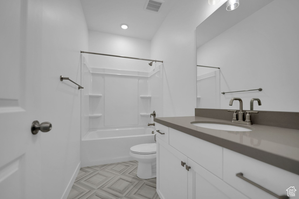 Bathroom with vanity, toilet, bathing tub / shower combination, and baseboards