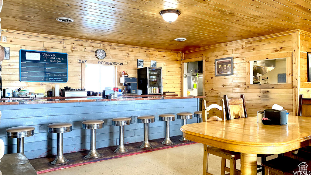 Kitchen with wooden ceiling, wooden walls, and visible vents