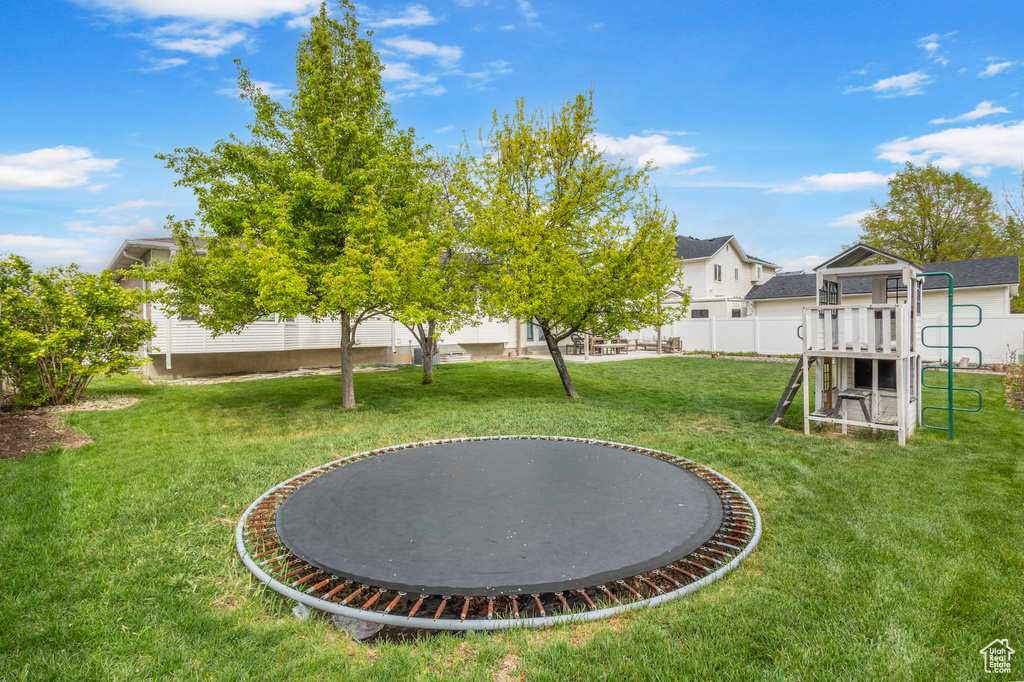 View of yard with a playground and fence