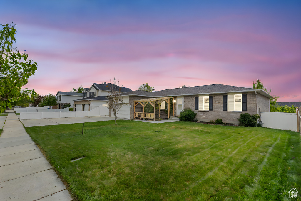 Single story home with a garage, a front lawn, fence, and driveway