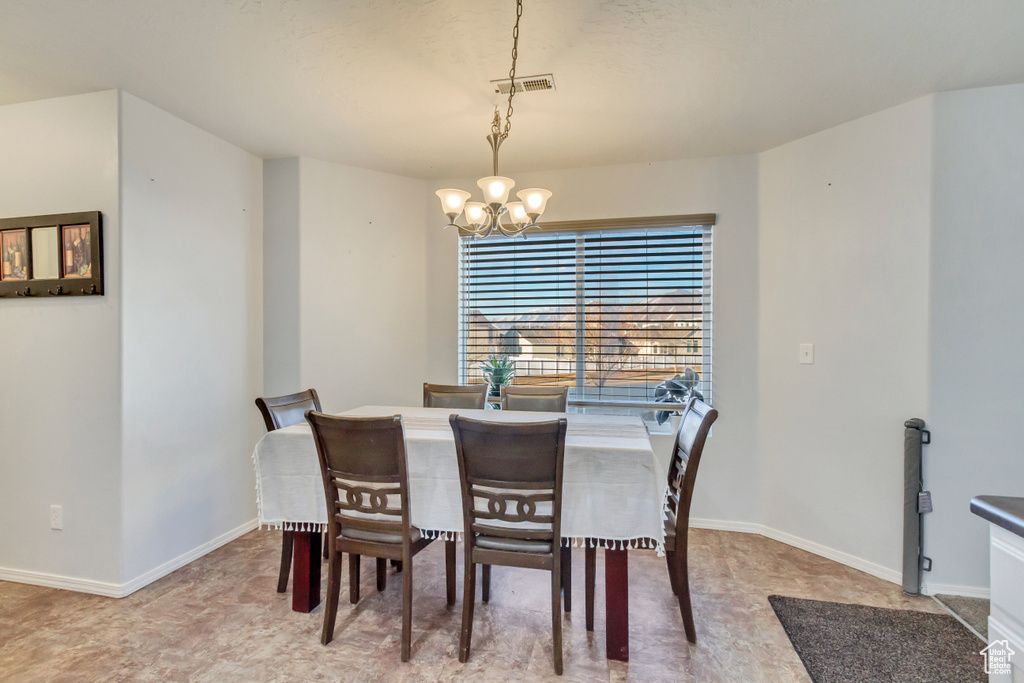 Dining room featuring a chandelier, visible vents, and baseboards