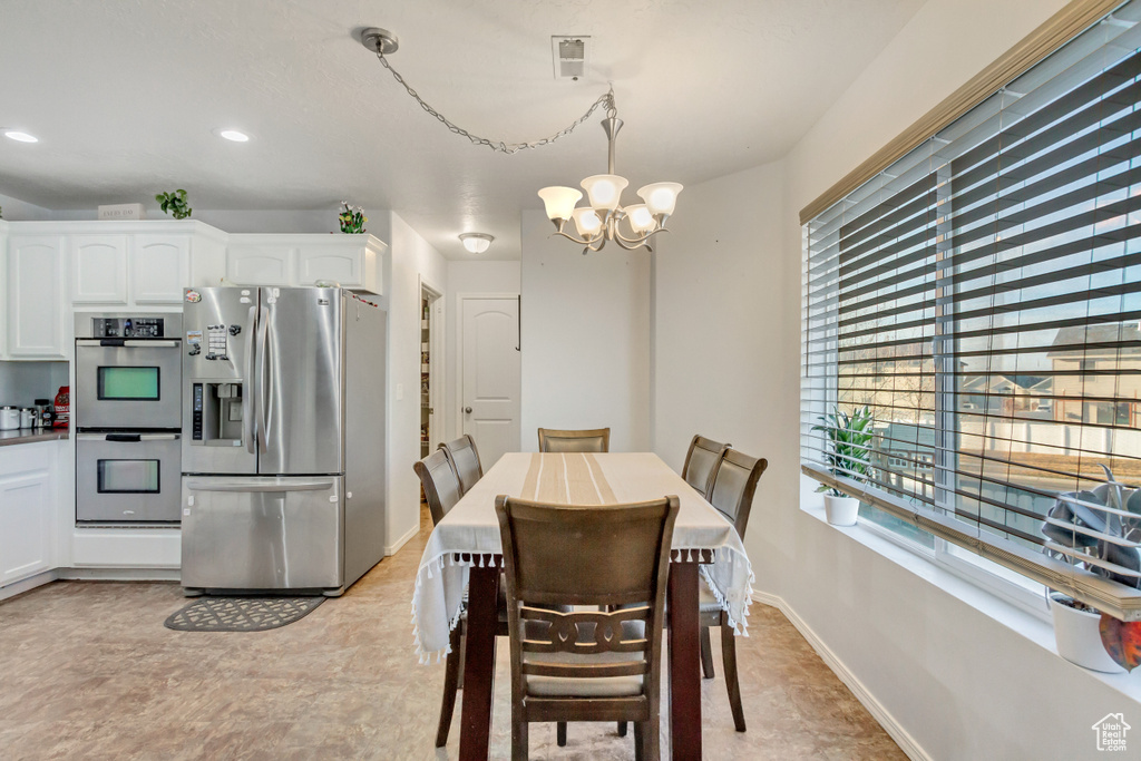 Dining area with recessed lighting, baseboards, and a chandelier