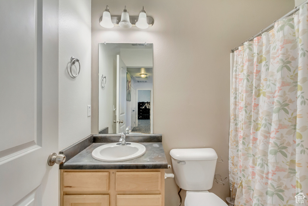 Full bath with a shower with shower curtain, toilet, and vanity
