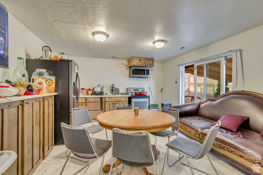 Dining area with a dry bar, visible vents, marble finish floor, and a textured ceiling