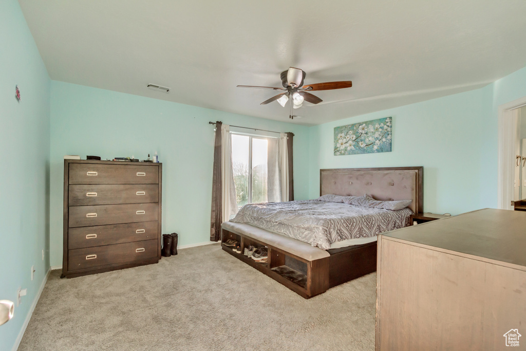 Bedroom featuring visible vents, light colored carpet, a ceiling fan, and baseboards
