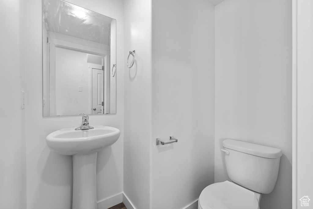Half bath with toilet and baseboards