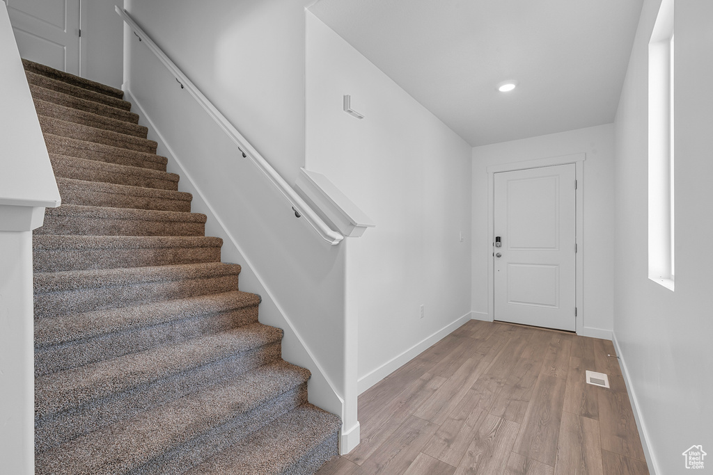 Stairs featuring visible vents, recessed lighting, baseboards, and wood finished floors