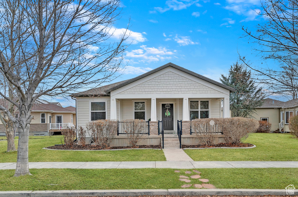 View of front of property with covered porch and a front lawn