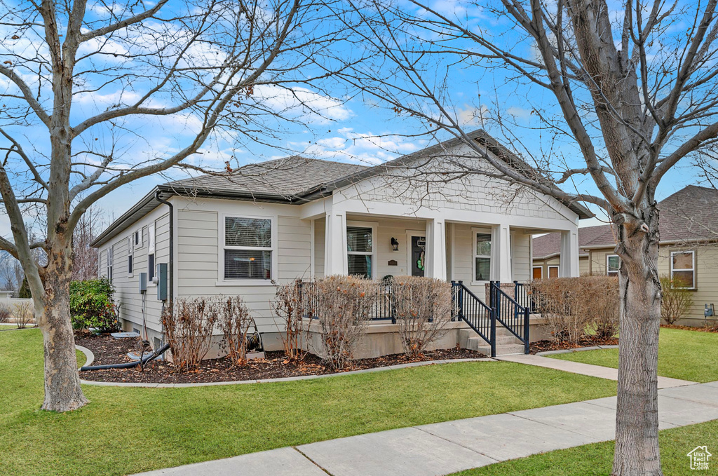 Bungalow-style house featuring a porch and a front yard