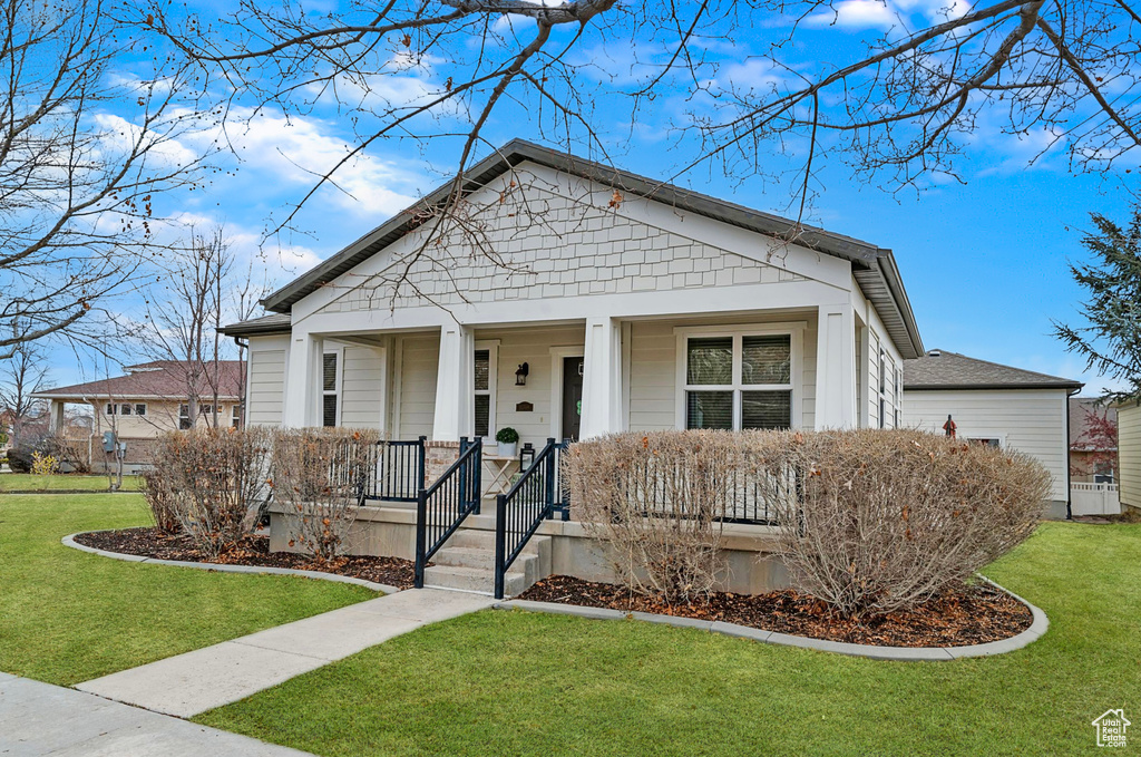 Bungalow-style home with covered porch and a front lawn