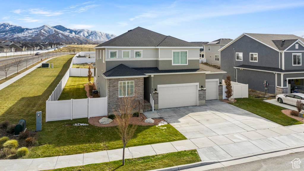 View of front of property with a shingled roof, fence, concrete driveway, stucco siding, and a garage