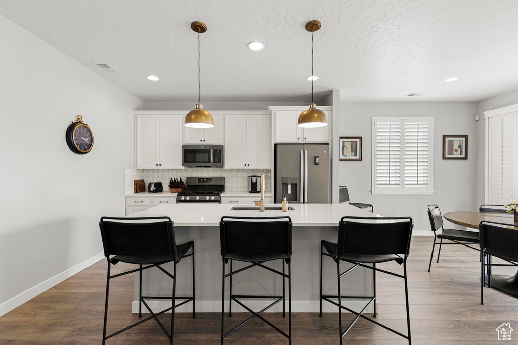 Kitchen featuring a sink, stainless steel appliances, visible vents, and light countertops