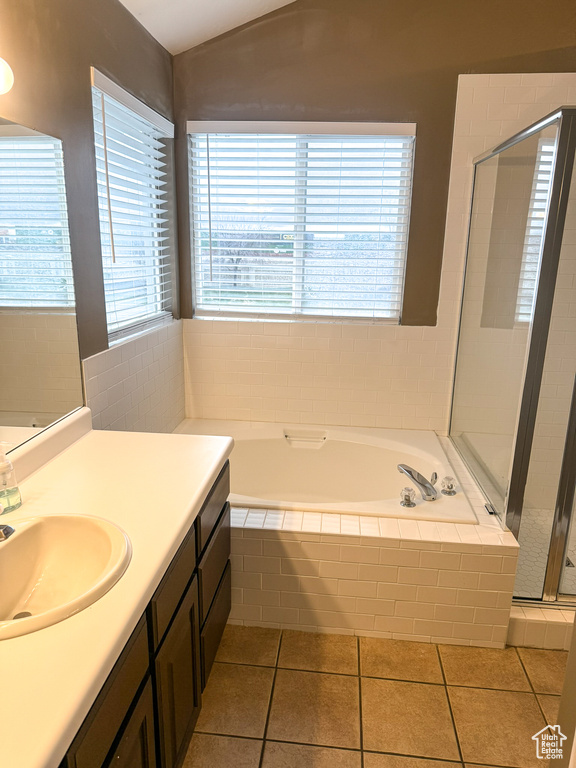 Bathroom with tile patterned flooring, a garden tub, vaulted ceiling, a stall shower, and vanity