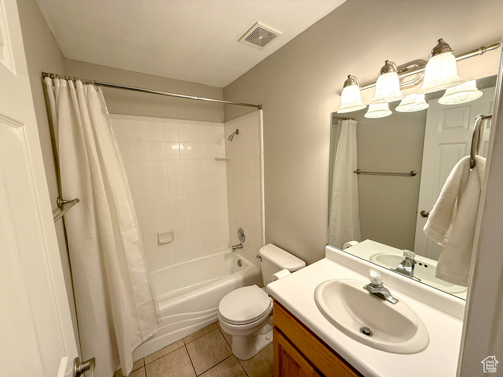 Bathroom featuring toilet, tile patterned floors, vanity, and shower / bathtub combination with curtain