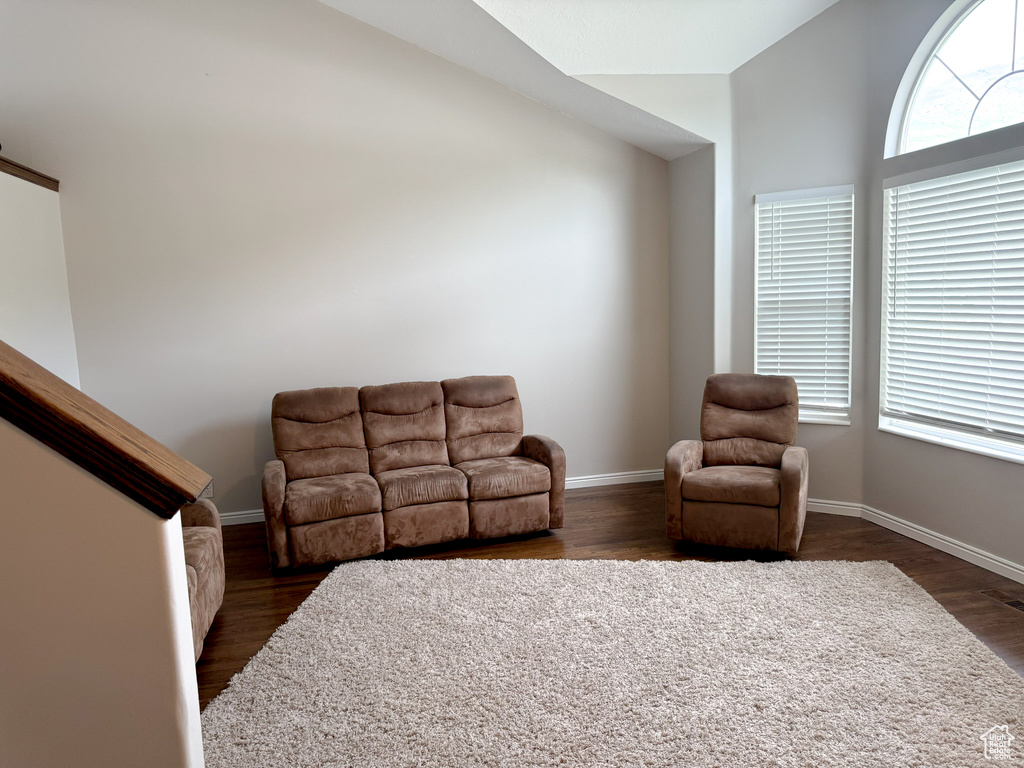 Living area featuring dark wood-type flooring and baseboards