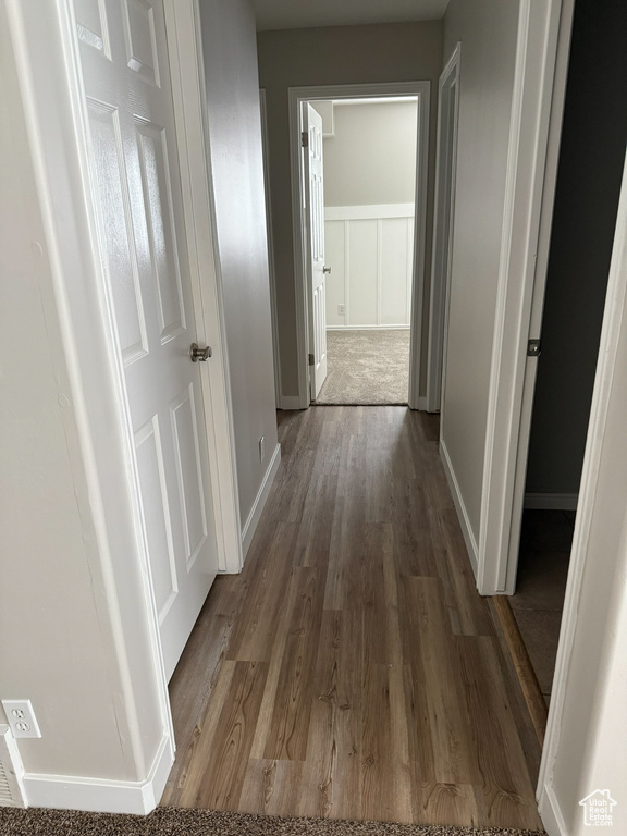 Hallway featuring wood finished floors and baseboards