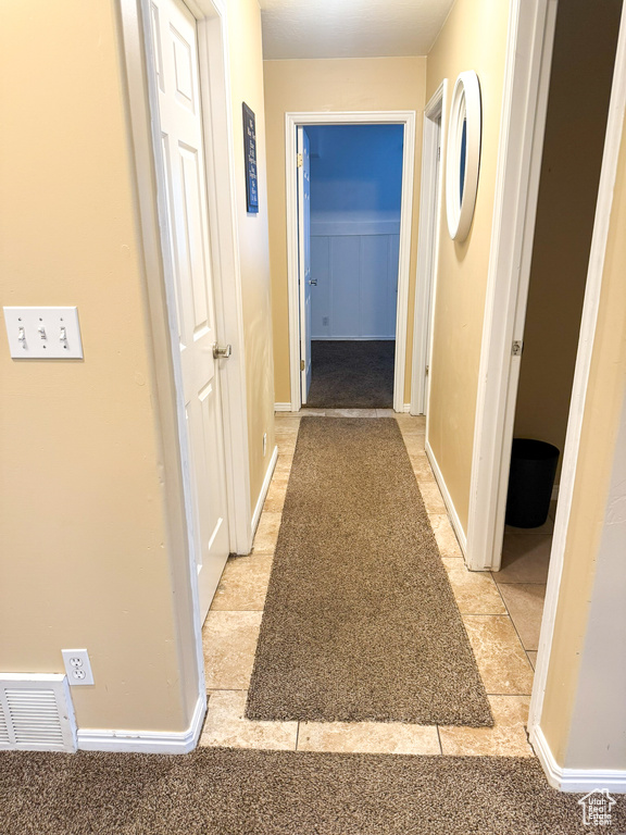 Corridor featuring visible vents and baseboards