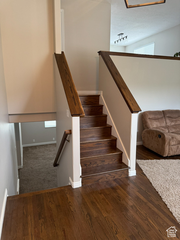 Staircase featuring wood finished floors and baseboards