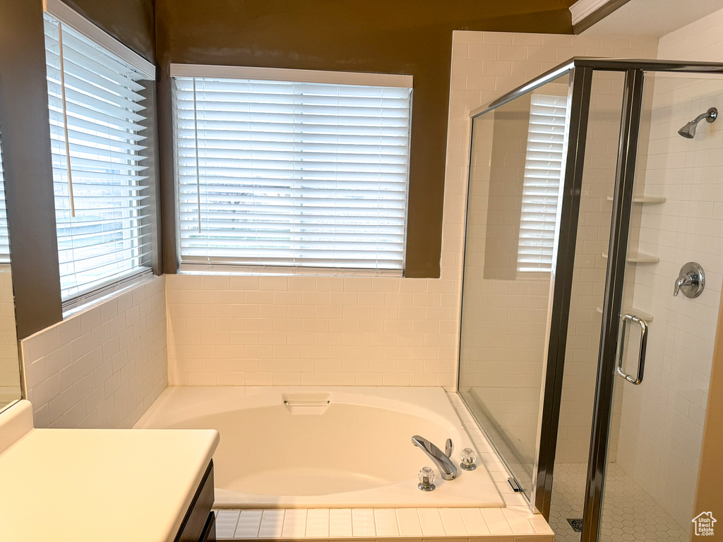 Bathroom with a stall shower, vanity, and a garden tub