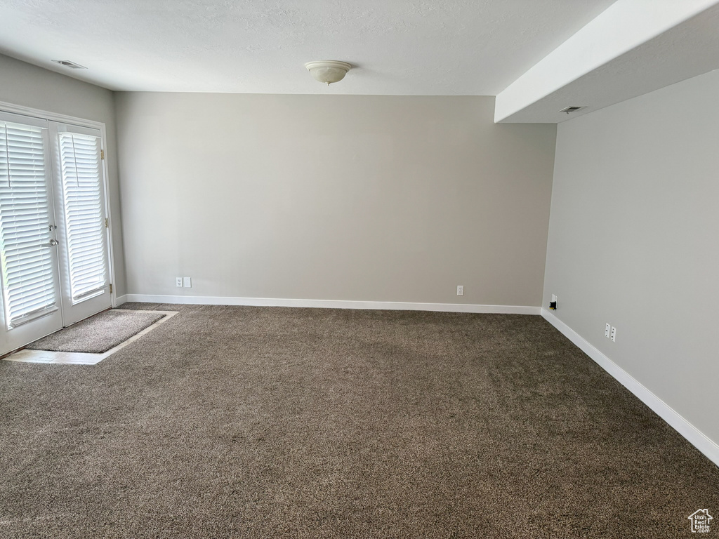 Carpeted spare room featuring baseboards