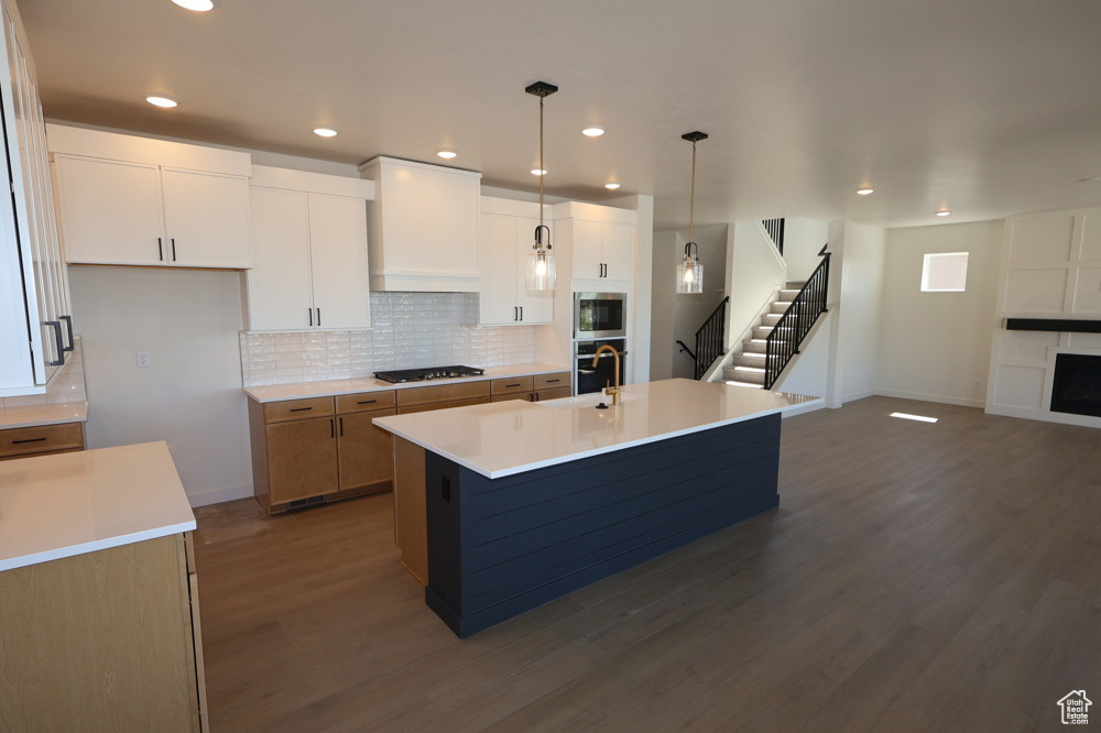 Kitchen featuring baseboards, tasteful backsplash, stainless steel appliances, and dark wood-style floors