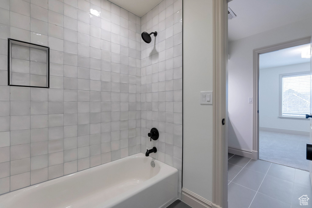 Full bathroom featuring tile patterned flooring, baseboards, and shower / washtub combination
