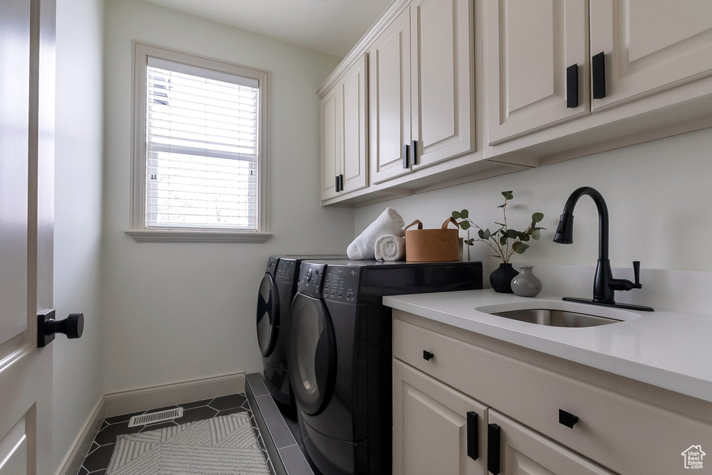 Laundry room featuring visible vents, baseboards, cabinet space, independent washer and dryer, and a sink