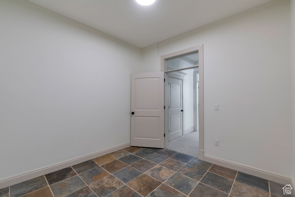 Unfurnished room with stone finish floor and baseboards