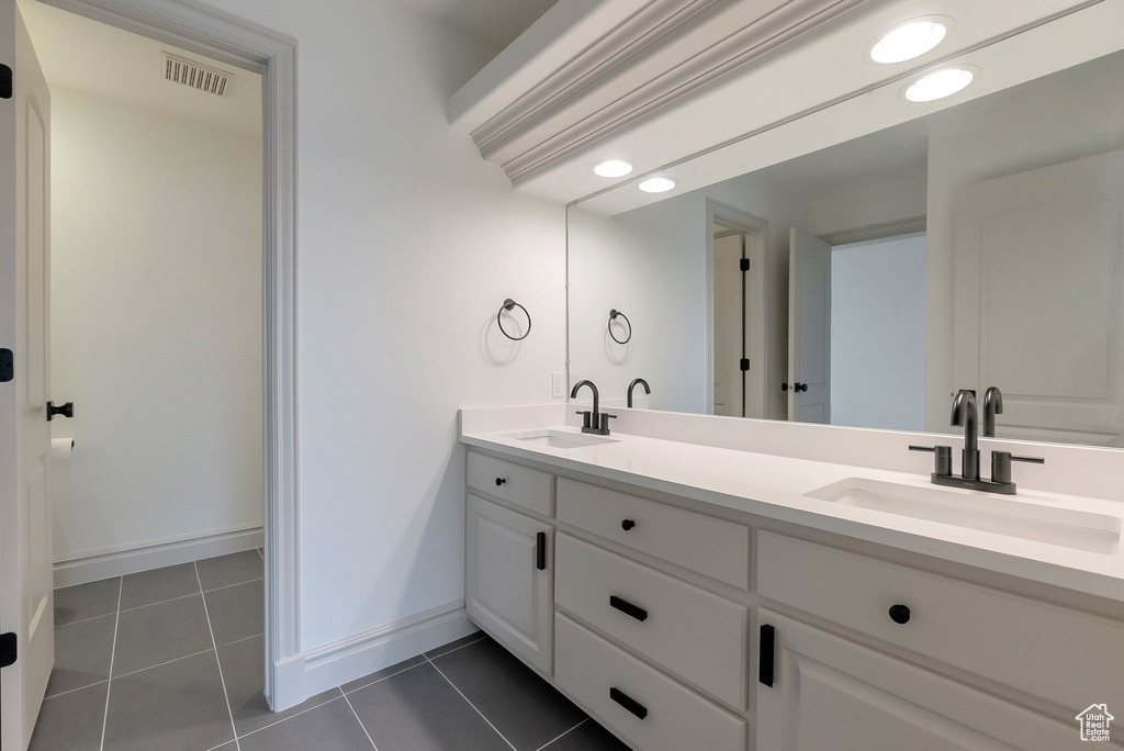 Full bathroom with tile patterned floors, double vanity, visible vents, and a sink