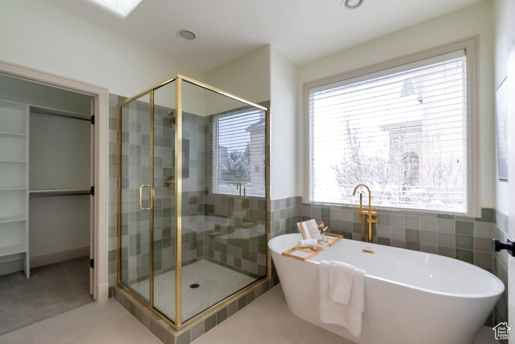 Full bathroom featuring tile patterned floors, a shower stall, tile walls, and a freestanding tub