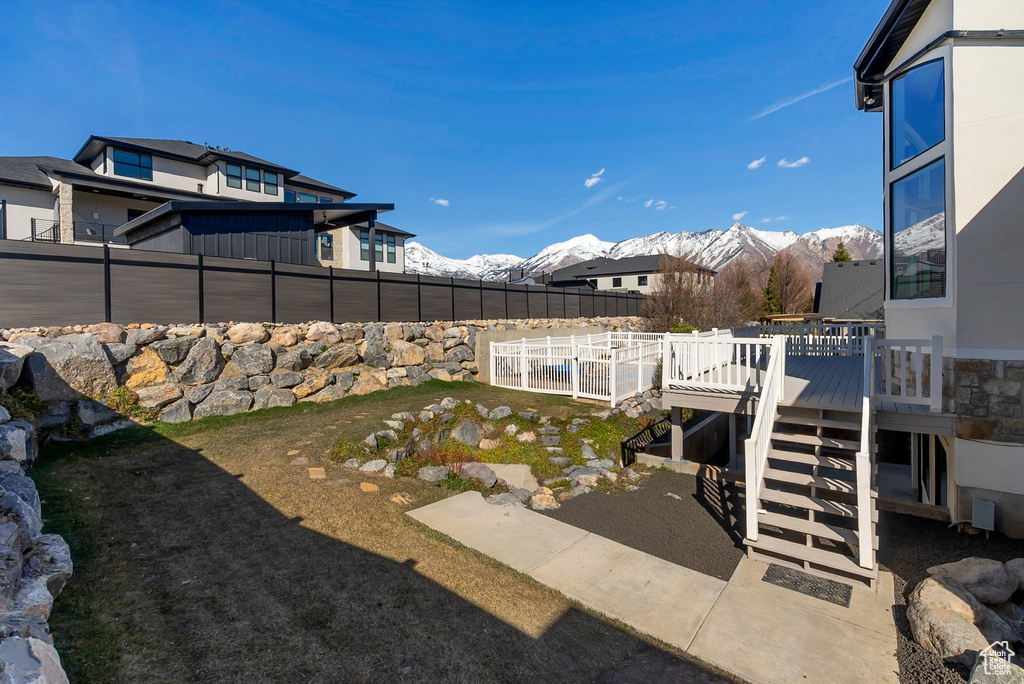View of yard with a deck with mountain view and a fenced backyard