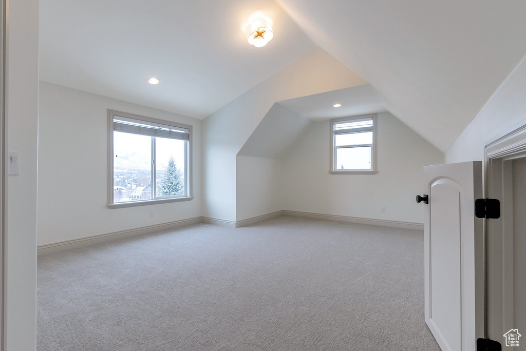 Additional living space featuring recessed lighting, light colored carpet, baseboards, and lofted ceiling