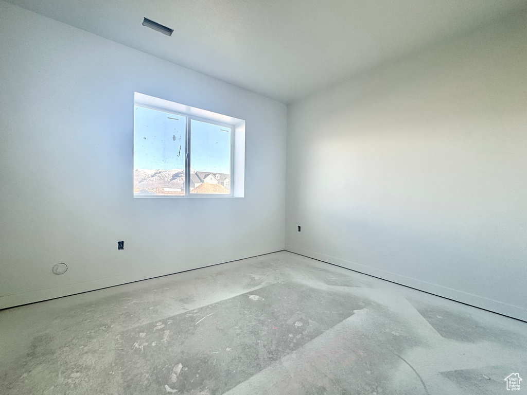 Unfurnished room featuring visible vents and unfinished concrete floors