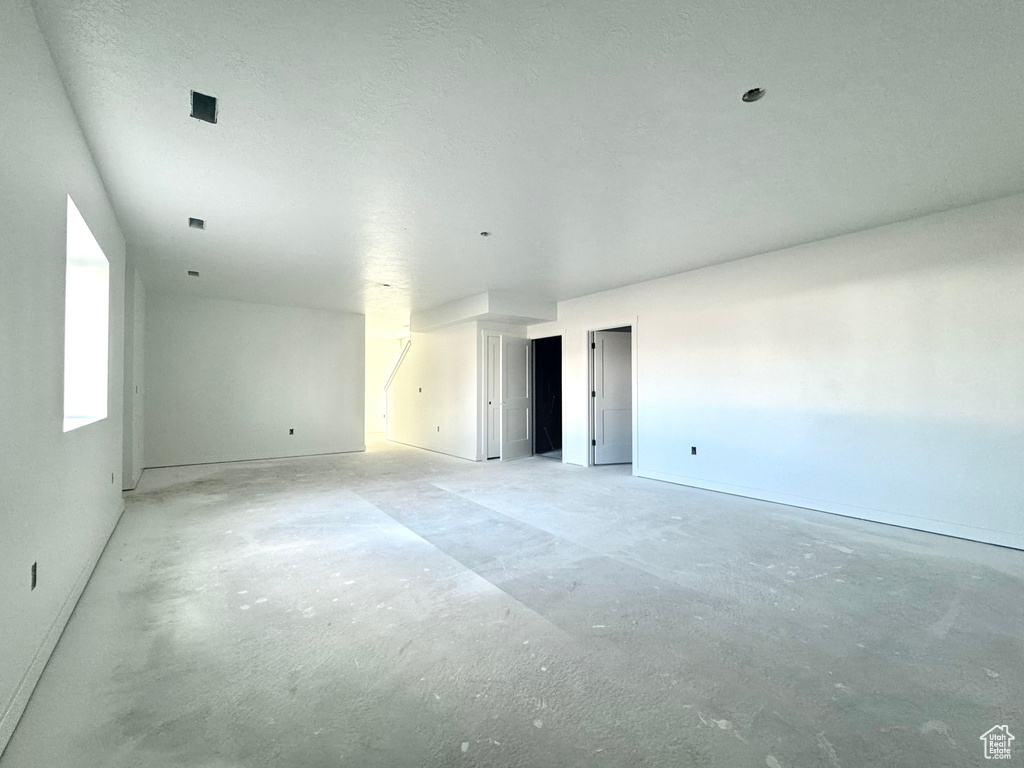 Spare room with unfinished concrete flooring