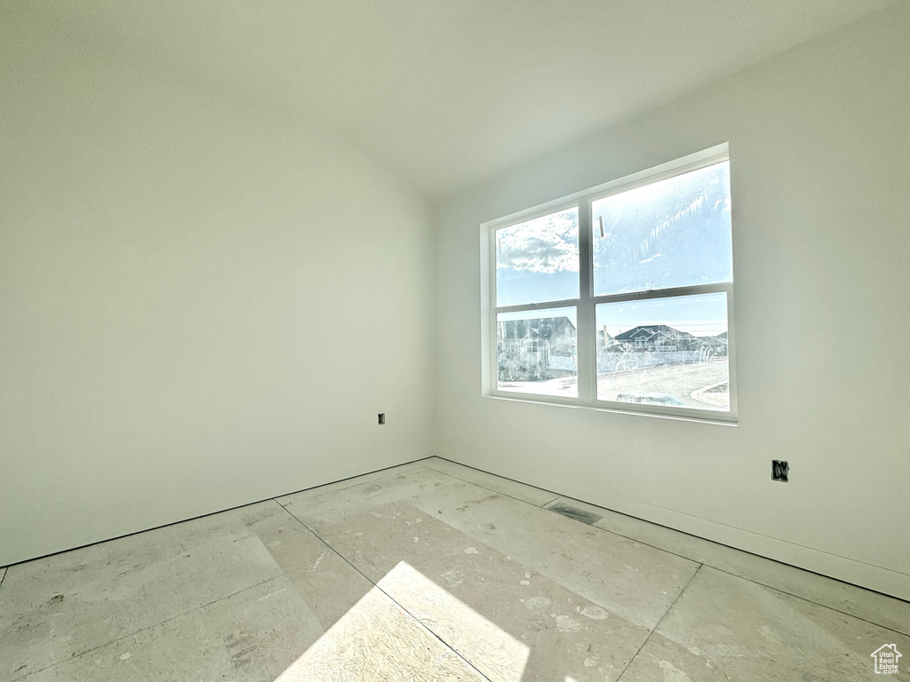 Spare room featuring visible vents and vaulted ceiling