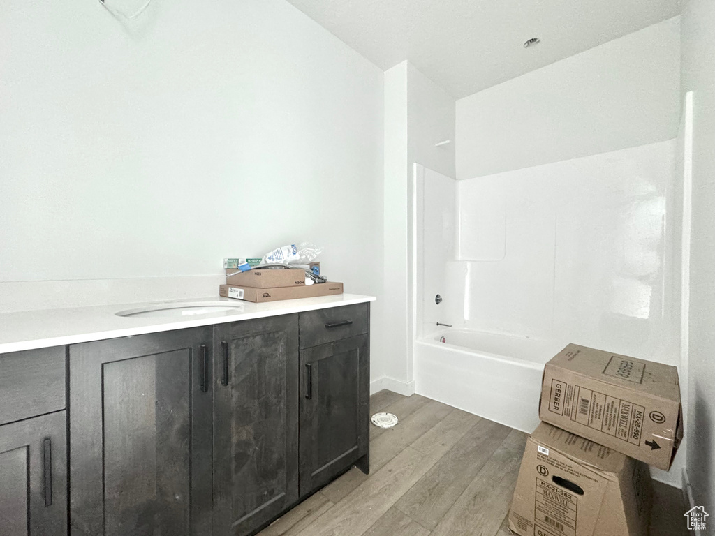 Bathroom with  shower combination, wood finished floors, and vanity