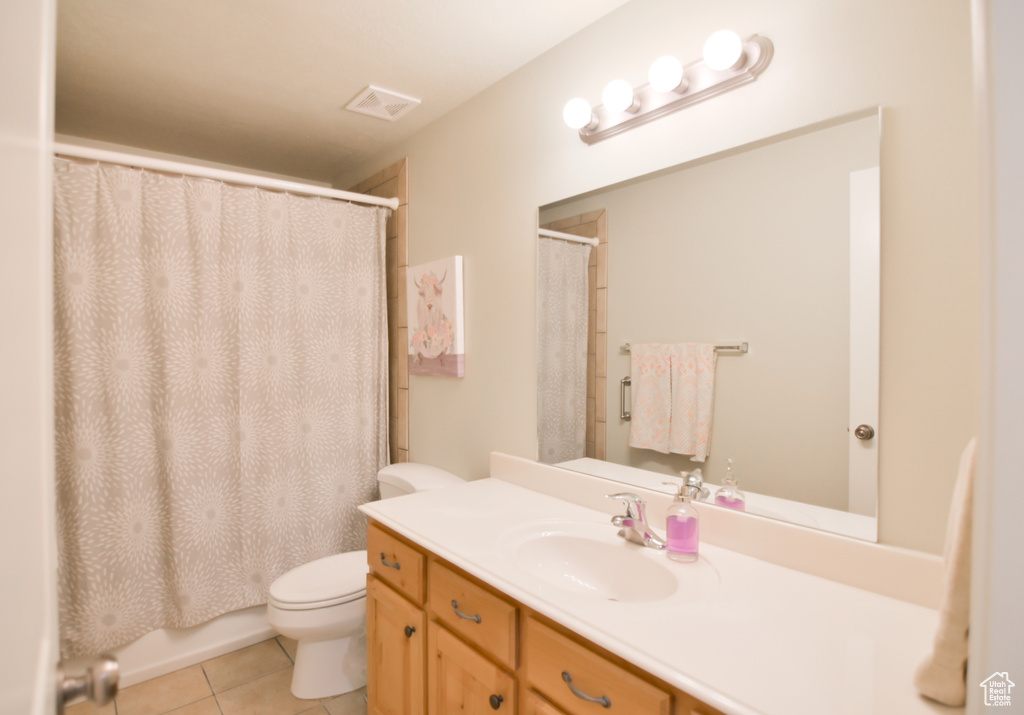 Full bath with vanity, a shower with curtain, visible vents, tile patterned flooring, and toilet