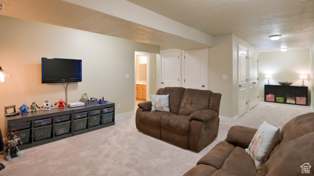 Carpeted living room with baseboards and visible vents