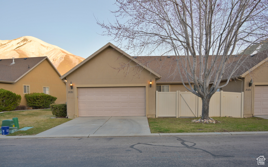 View of front of house with a front yard, fence, an attached garage, stucco siding, and concrete driveway