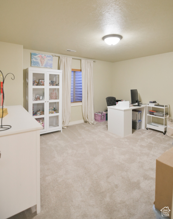 Unfurnished office with visible vents, a textured ceiling, and carpet floors