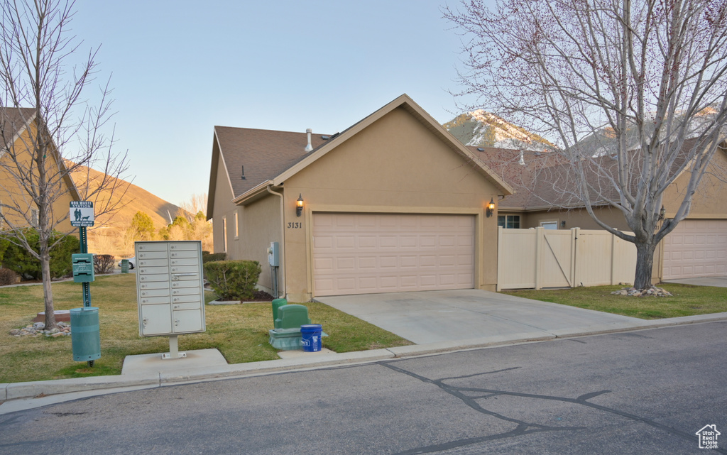 View of front of house with stucco siding, a front lawn, fence, concrete driveway, and a garage