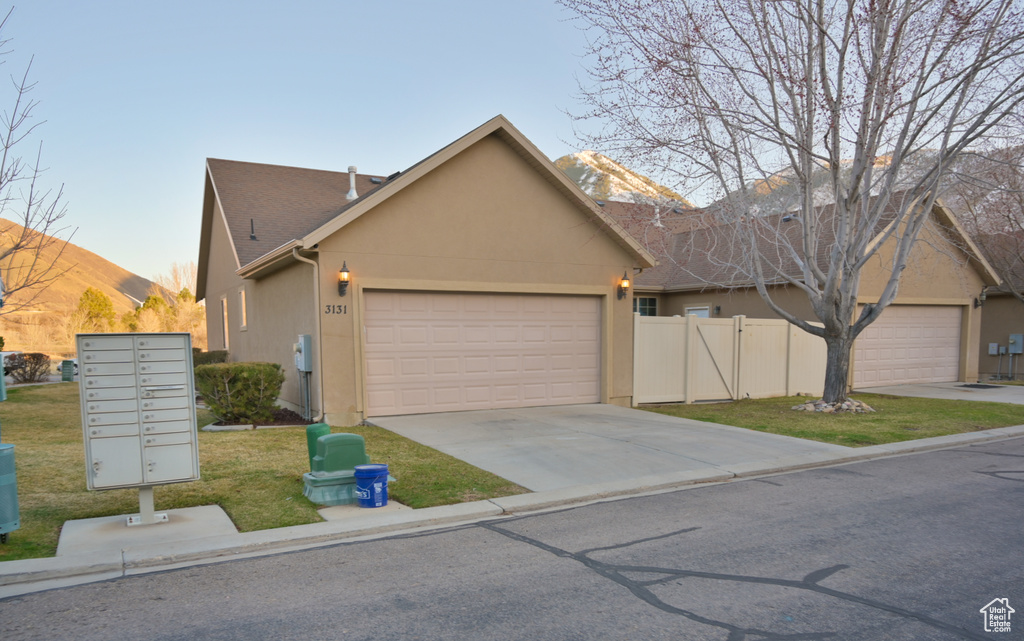Ranch-style house with stucco siding, a front lawn, fence, concrete driveway, and a garage