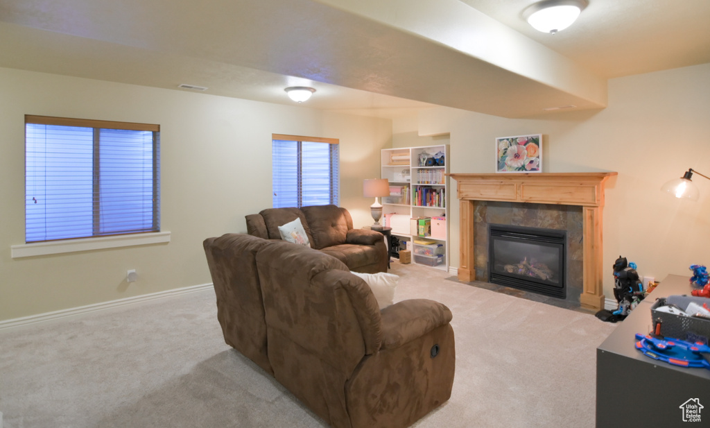 Living area featuring visible vents, baseboards, carpet, and a premium fireplace