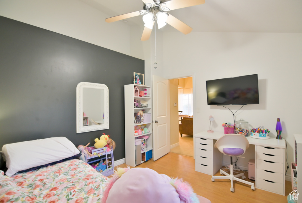 Bedroom featuring a ceiling fan, vaulted ceiling, baseboards, and light wood-type flooring