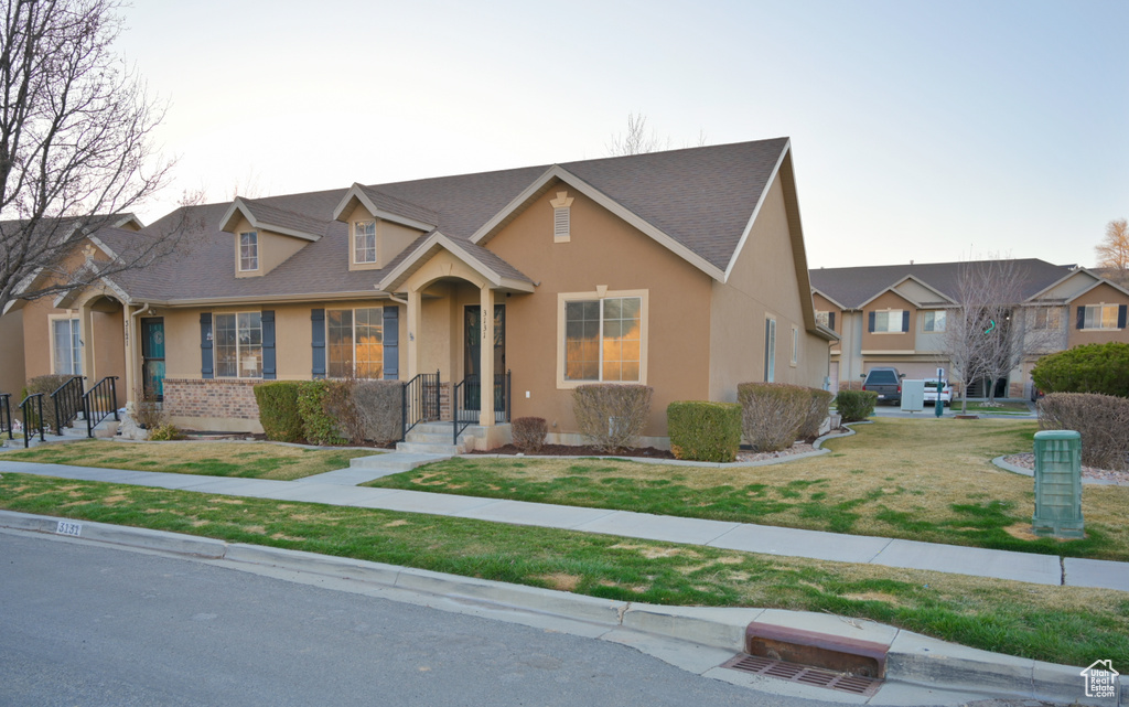 View of front of home with stucco siding and a front yard