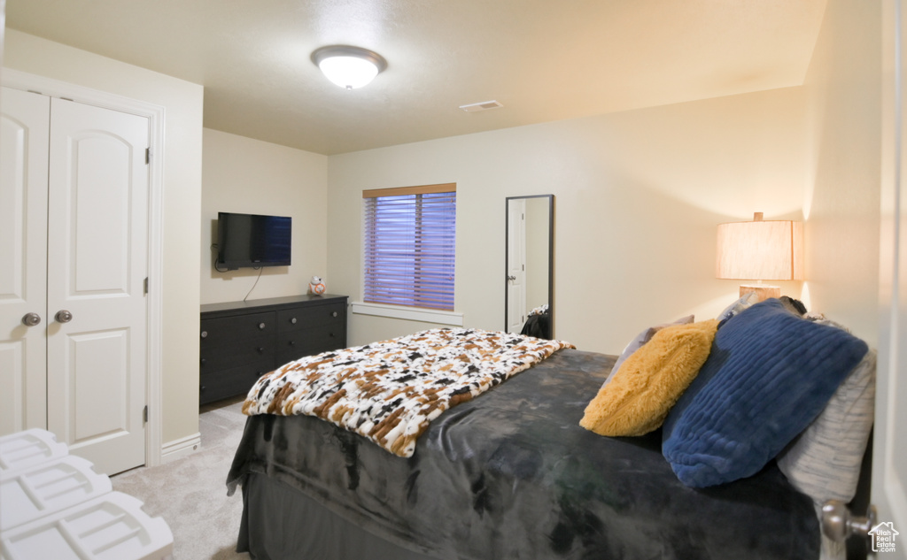 Bedroom with visible vents and light colored carpet